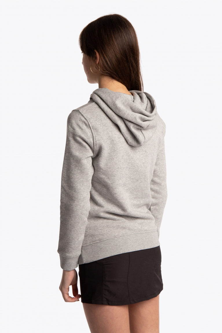 Girl wearing the Osaka kids hoodie in grey with green star logo. Side/back view
