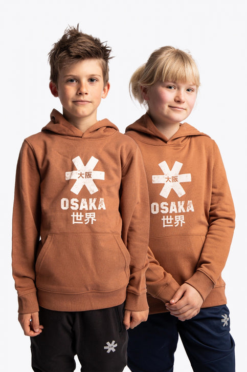 Boy and girl wearing the Osaka kids vintage hoodie in caramel with logo in white. Front view