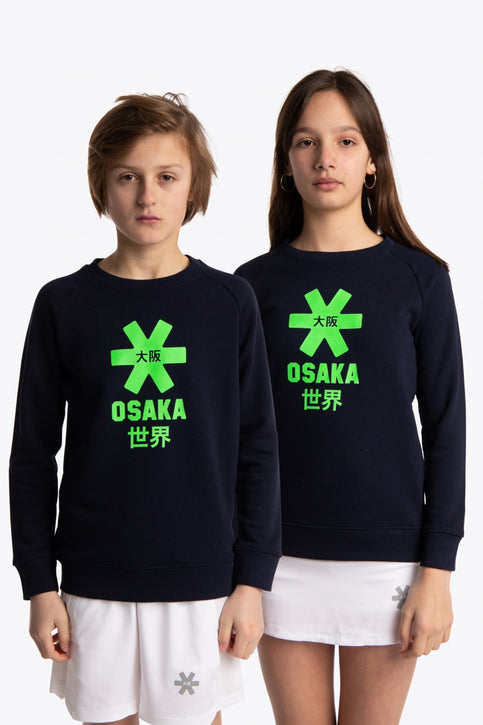 Boy and girl wearing the Osaka kids sweater in navy with logo in green. Front view
