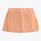 Osaka women ball skort in peach with logo in grey. Back flatlay view