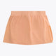 Osaka women ball skort in peach with logo in grey. Back flatlay view