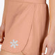 Woman wearing the Osaka women ball skort in peach with logo in grey. Detail side view
