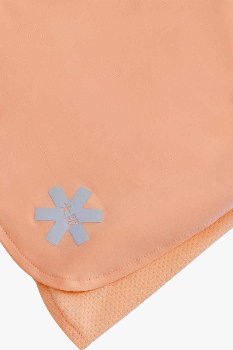 Osaka women ball skort in peach with logo in grey. Detail logo view