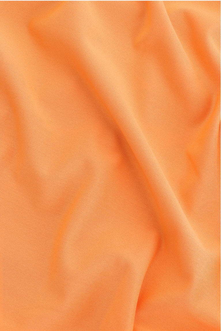 Osaka women ball skort in orange with logo in white. Detail fabric view