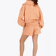 Osaka women half zip sweater in peach with white logo. Back view