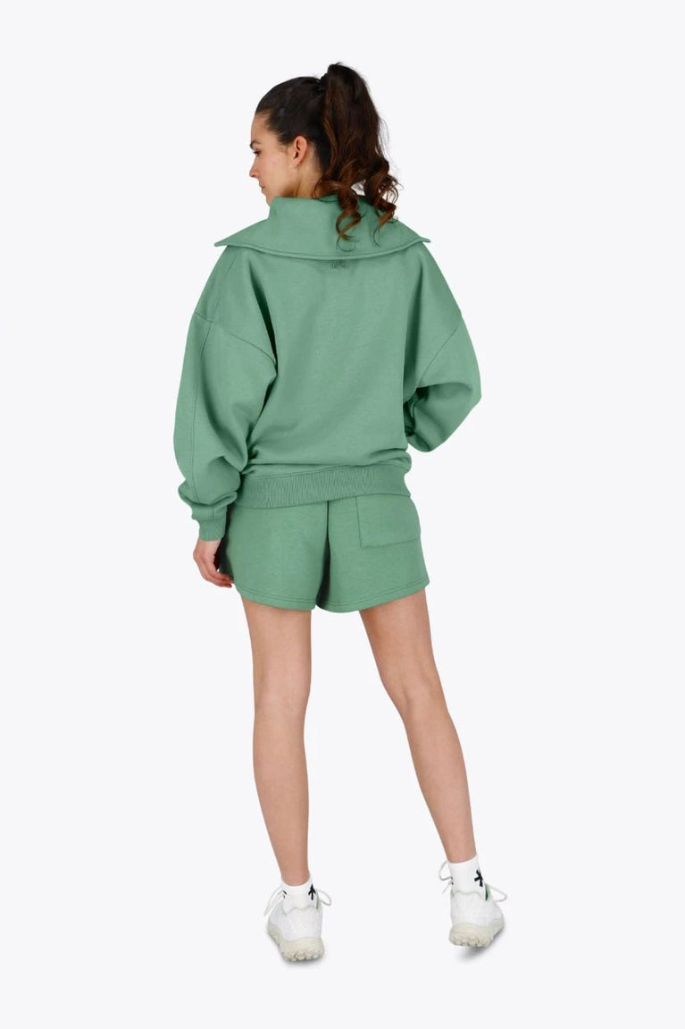 Woman wearing the Osaka women half zip sweater green. Back view