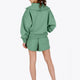 Woman wearing the Osaka women half zip sweater green. Back view