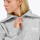 Woman wearing the Osaka women half zip sweater in heather grey with white logo. Front detail neck view