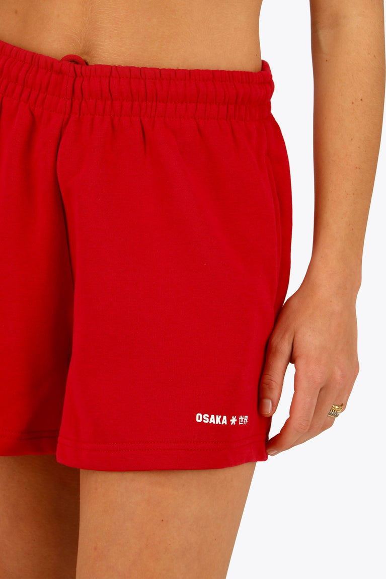 Osaka women shorts in red with logo in white. Front detail logo view