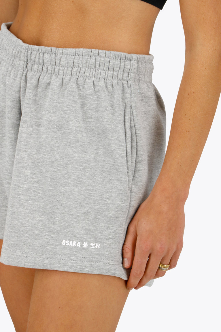 Woman wearing the Osaka women shorts in heather grey with logo in white. Front view