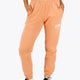 Woman wearing the Osaka women sweatpants in peach with logo in white. Front view