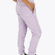 Woman wearing the Osaka women sweatpants in light purple with logo in white. Side / back view