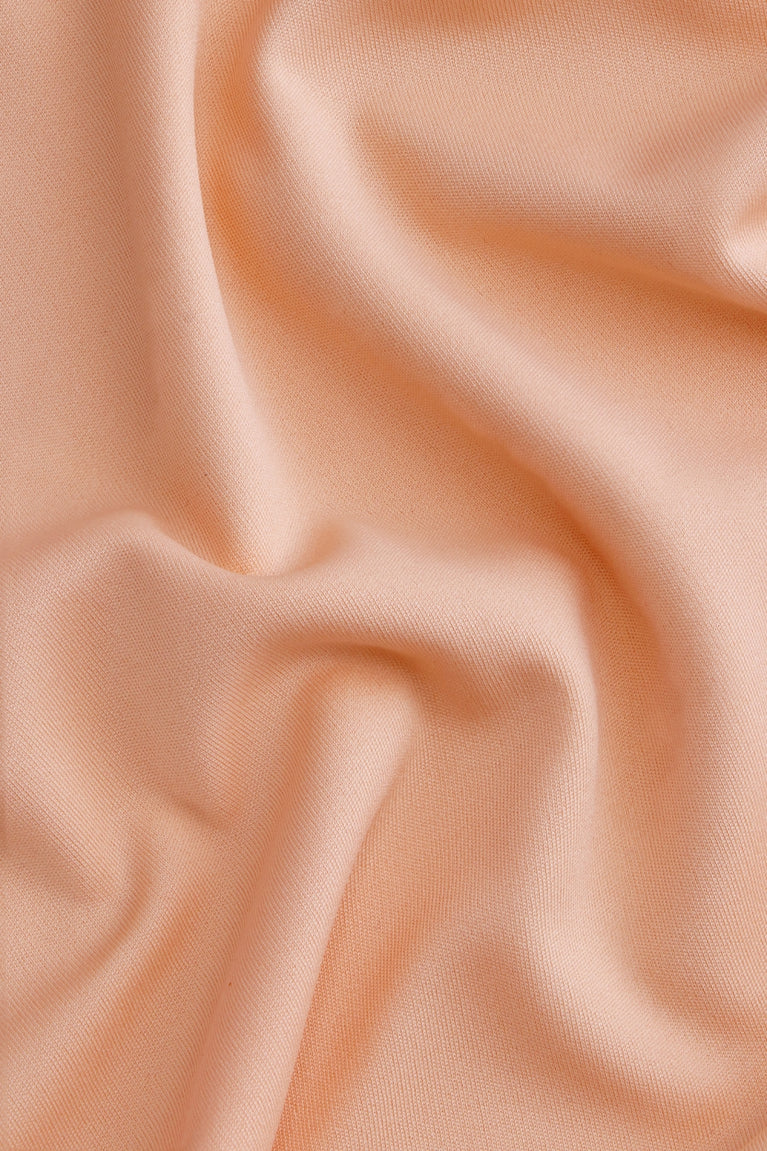 Osaka women tee short sleeve in peach with logo in grey. Detail fabric view