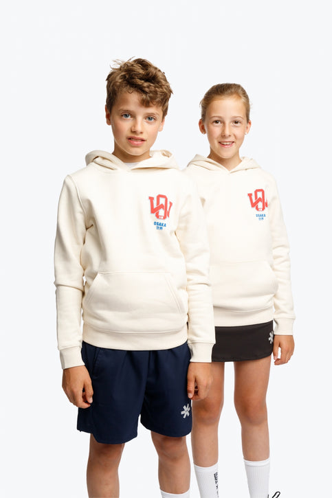 Boy and girl wearing the Osaka kids hoodie in natural raw with college letters in orange and logo in blue. Front view