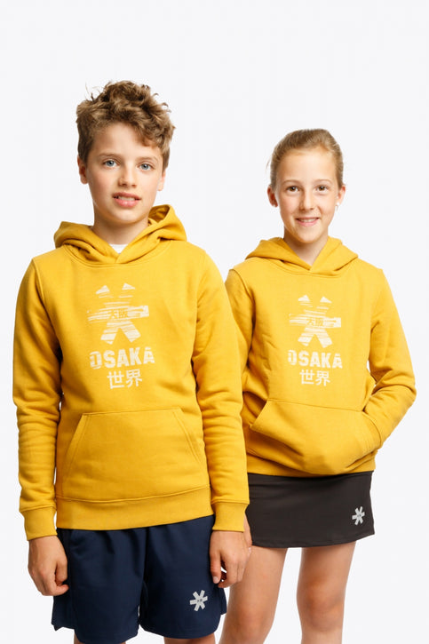 Boy and girl wearing the Osaka kids hoodie in ochre and marker logo in white. Front view
