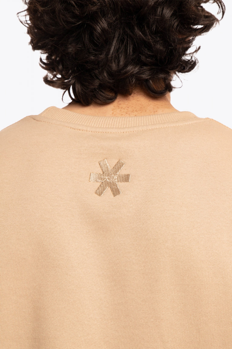 Man wearing the Osaka x Buenas Open sweater in stone. Back detail logo view