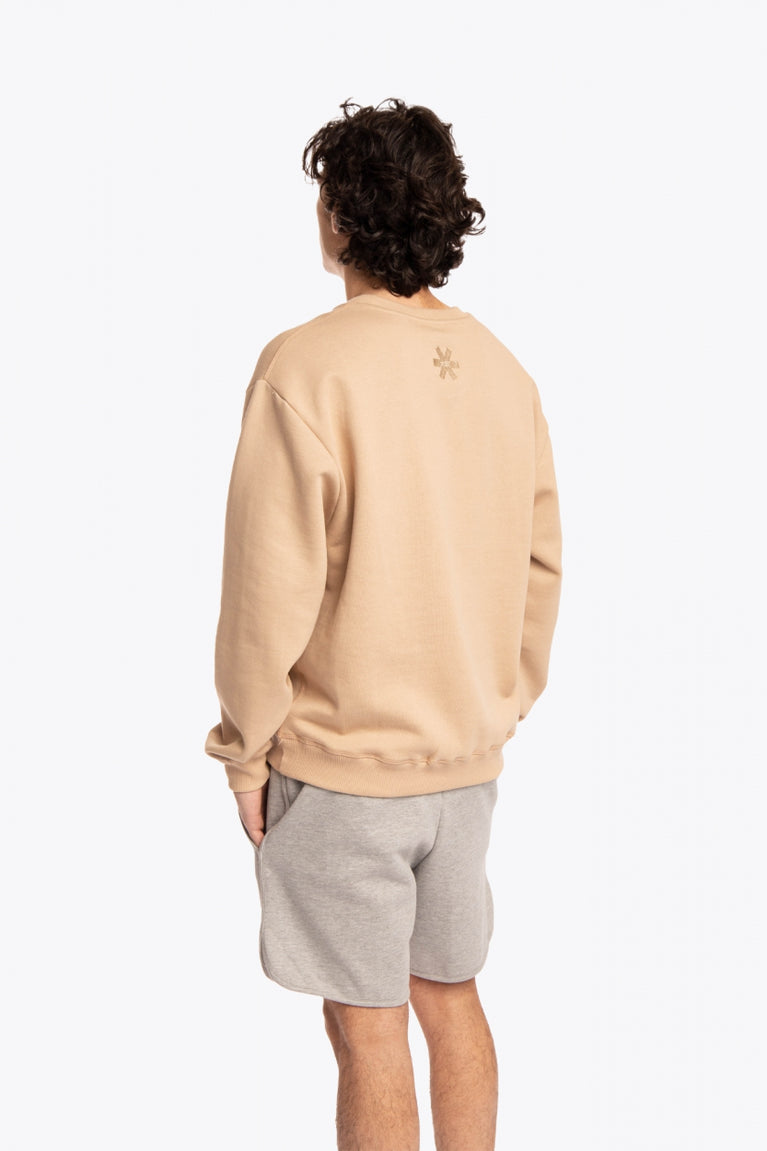 Man wearing the Osaka x Buenas Open sweater in stone. Back view