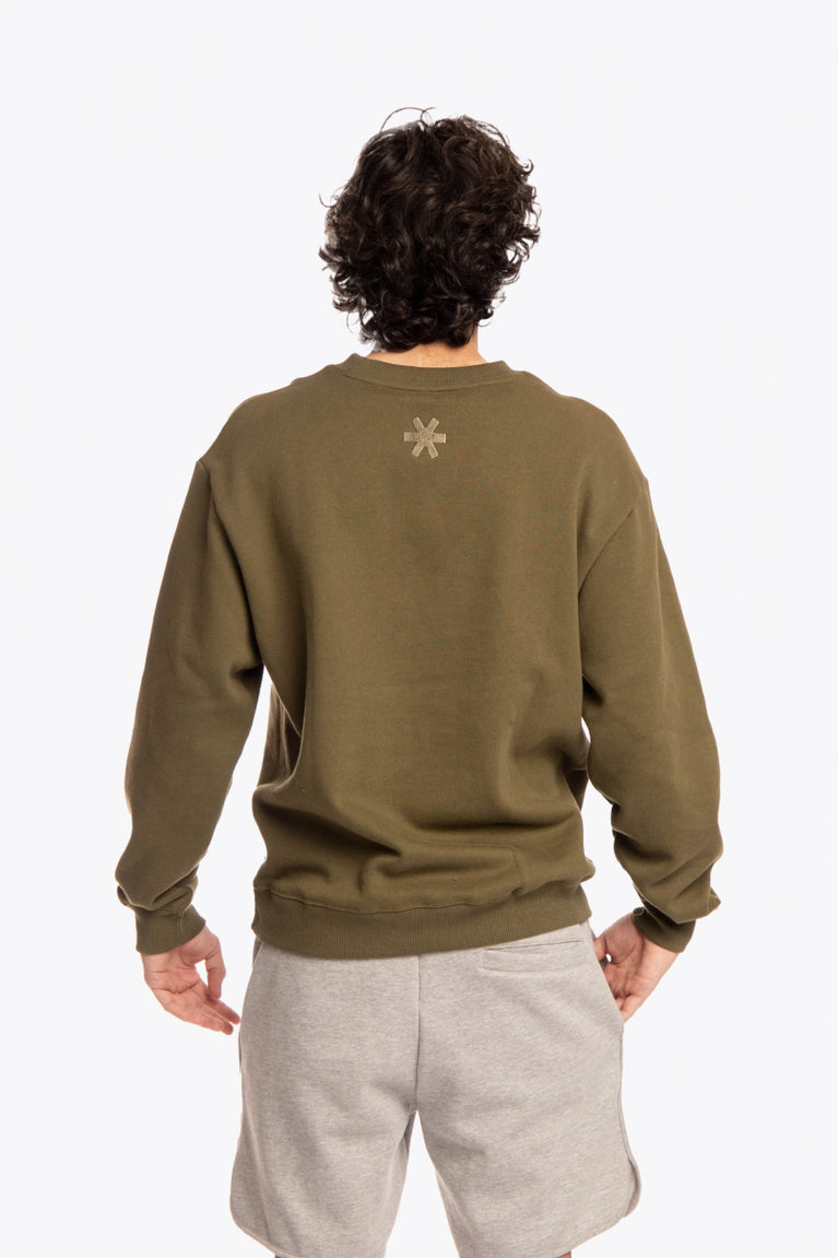 Man wearing the Osaka x Buenas Open sweater in army green. Back view