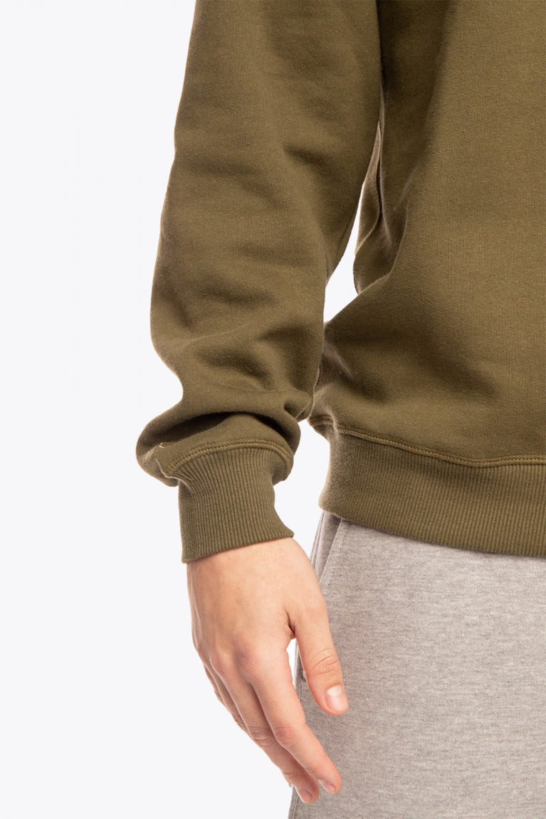 Man wearing the Osaka x Buenas Open sweater in army green. Front sleeve view