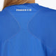 Woman wearing the Osaka women v-neck tech dress in princess blue with logo in grey. Back detail logo view