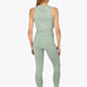 Woman wearing the Osaka women tech tank top in jadeite with logo in grey. Back view