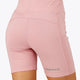 Woman wearing the Osaka women tech short thights in pink with grey logo. Back view