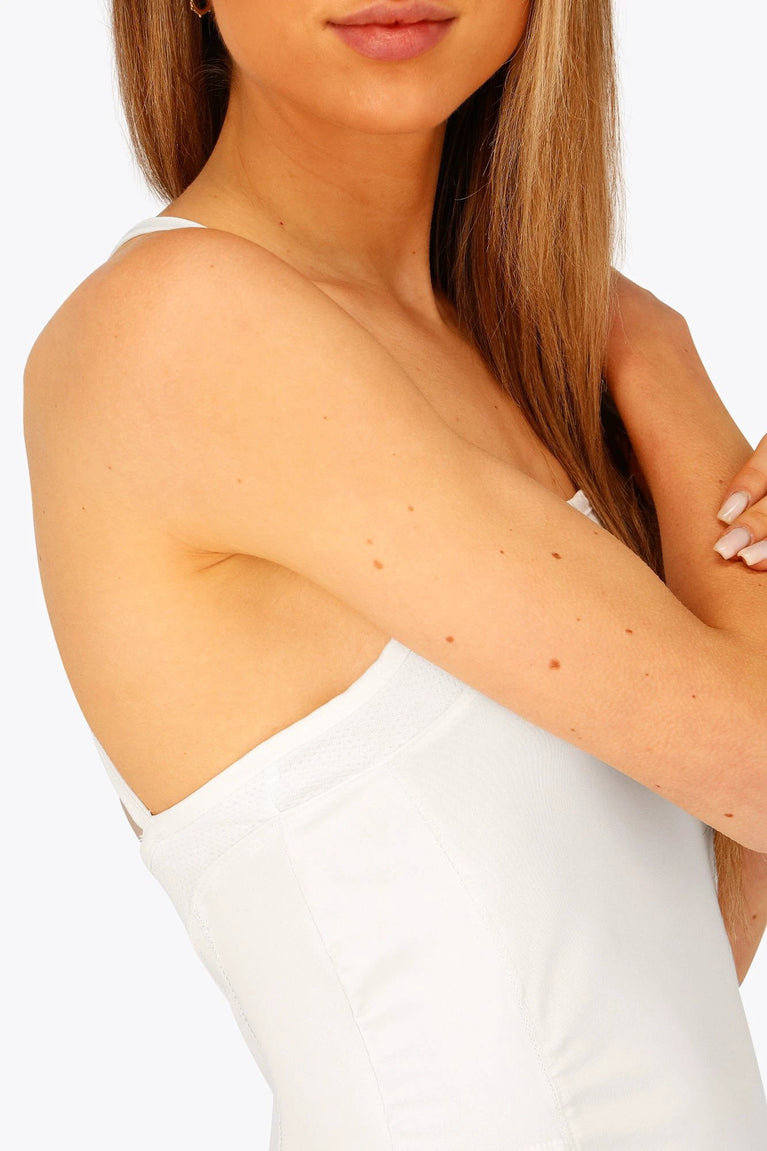 Woman wearing the Osaka women pleated tech dress in white with grey logo. Side detail view