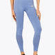 Woman wearing the Osaka women shimuresu leggin in manor blue with logo in grey. Front view