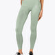 Woman wearing the Osaka women shimuresu leggin in jadeite with logo in grey. Front view
