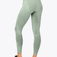 Woman wearing the Osaka women shimuresu leggin in jadeite with logo in grey. Back view
