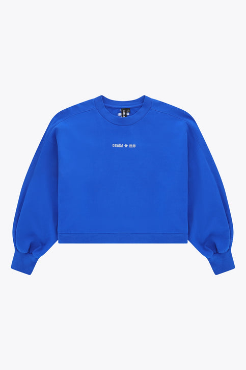 Osaka women cropped hoodie in princess blue with logo in white. Front flatlay view