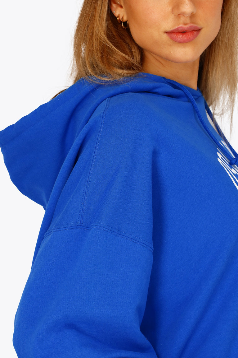 Osaka women cropped hoodie inprincess blue with college logo in white. Side shoulders view