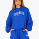 Woman wearing the Osaka women cropped hoodie inprincess blue with college logo in white. Front view