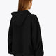 Woman wearing the Osaka women cropped hoodie in black with college logo in white. Back view
