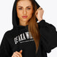 Woman wearing the Osaka women cropped hoodie in black with college logo in white. Front view