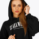 Woman wearing the Osaka women cropped hoodie in black with college logo in white. Front view