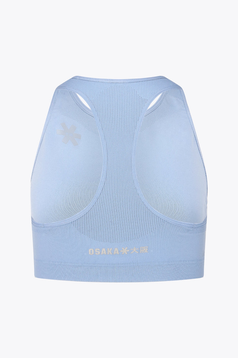 Osaka women tech sports bra in manor blue with logo in grey. Back flatlay view