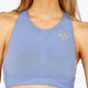 Woman wearing the Osaka women tech sports bra in manor blue with logo in grey. Front detail logo view