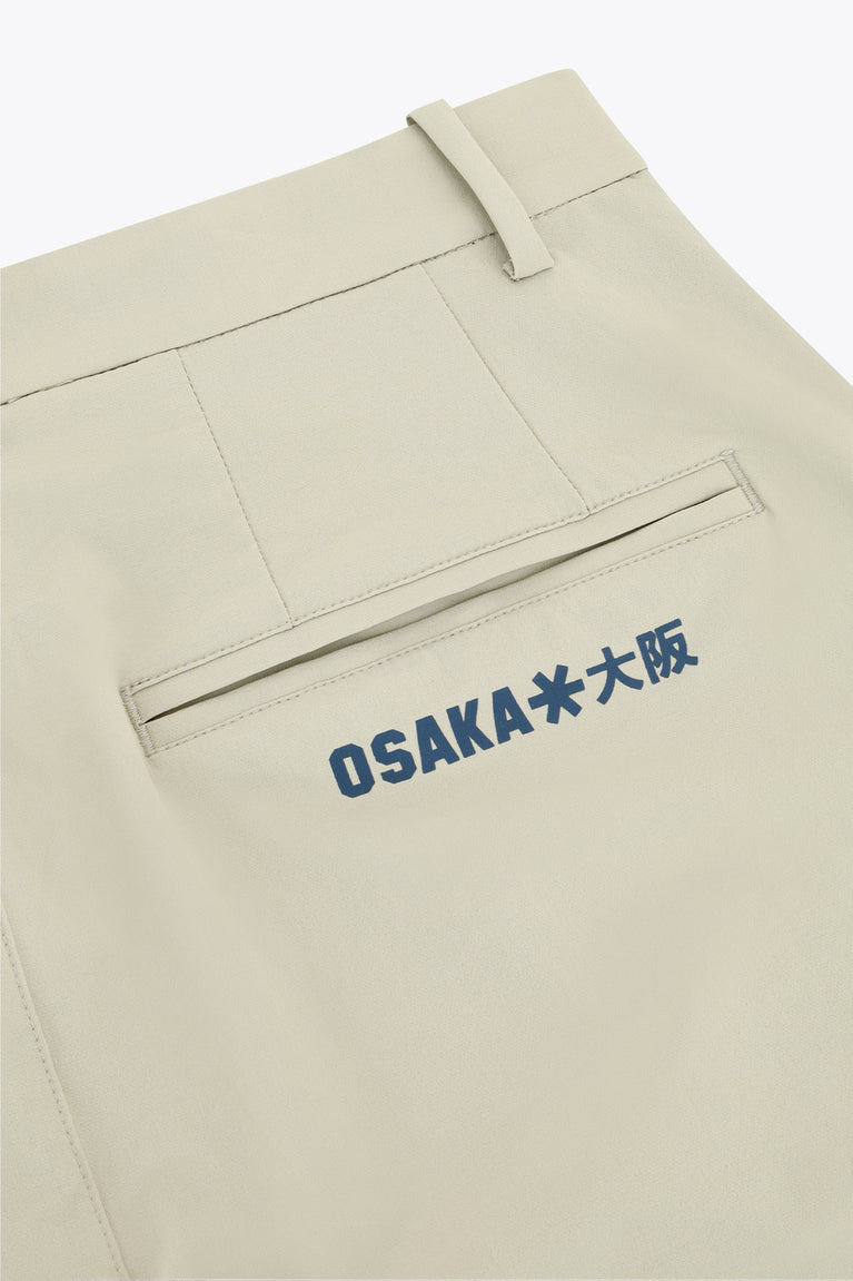 Beige technical golf pants with blue logo embroidery on front pocket panel