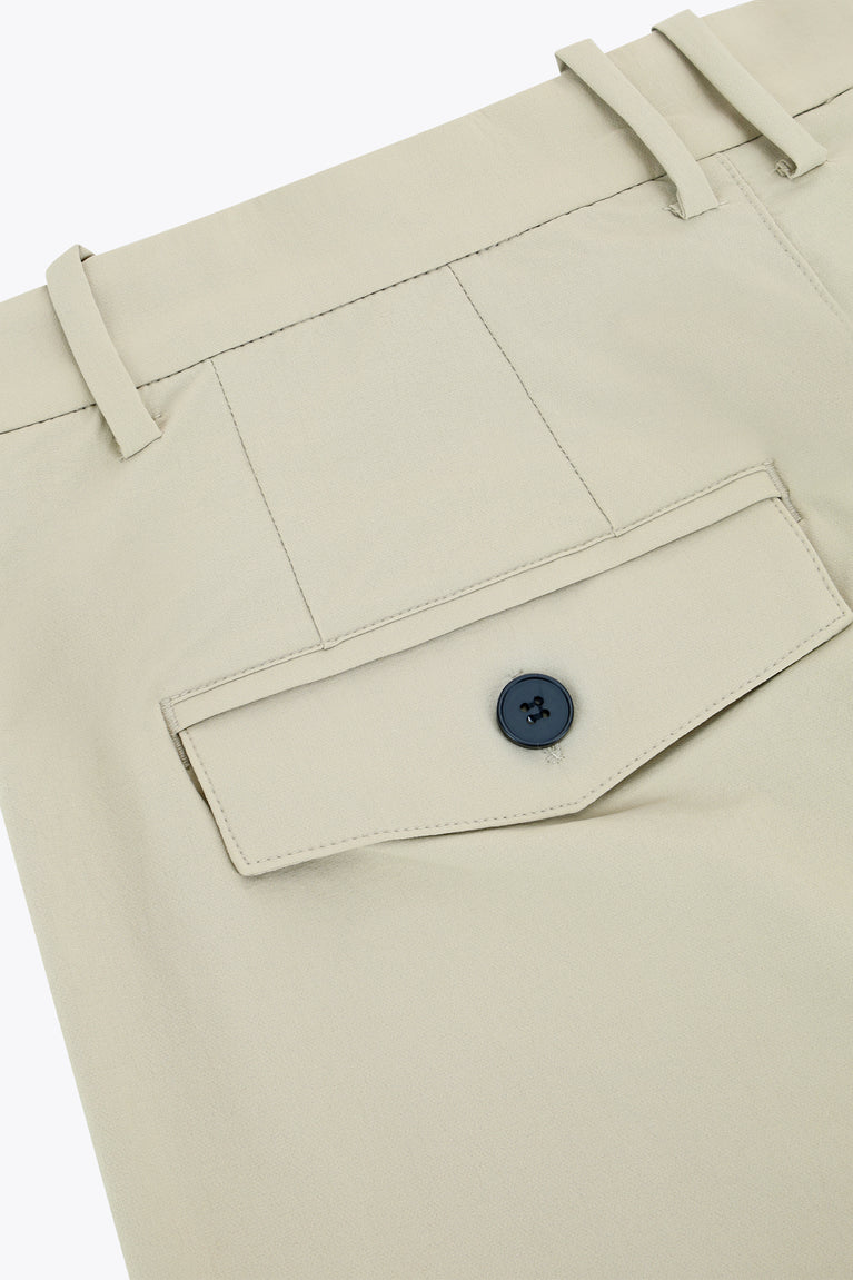Beige technical golf pants with waistband, dark button, and welt pocket flap