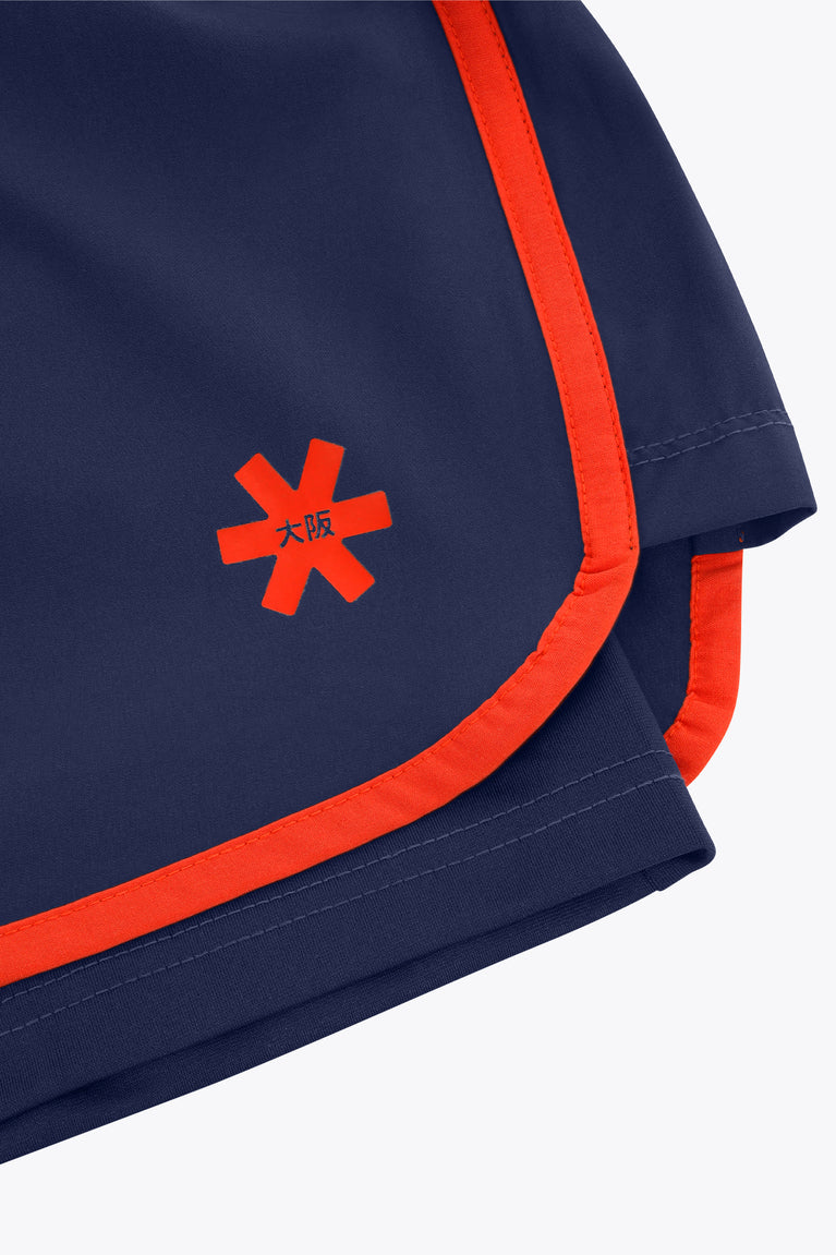 Navy court short with orange trim, red cross logo, and double-layer hem