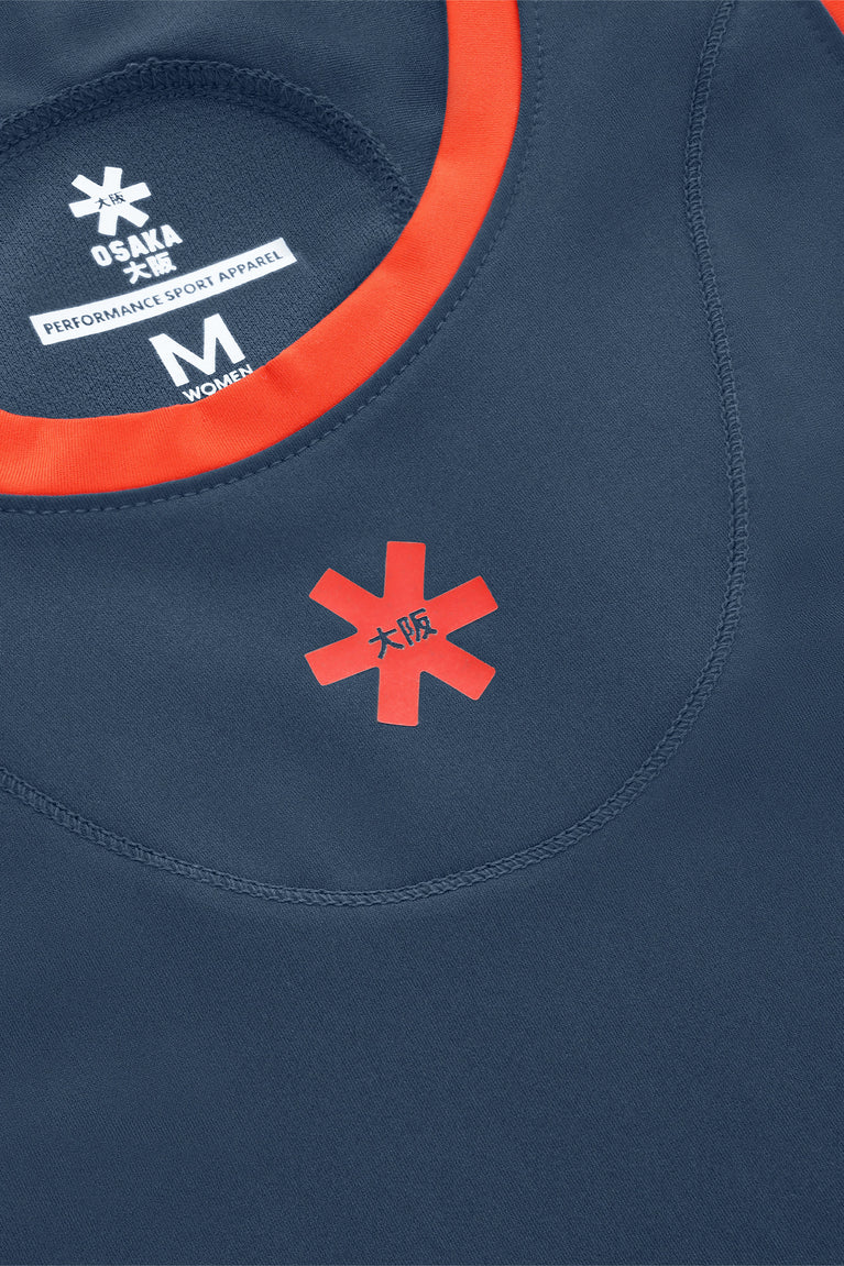 Women’s navy dress neckline with red trim and brand logo patch