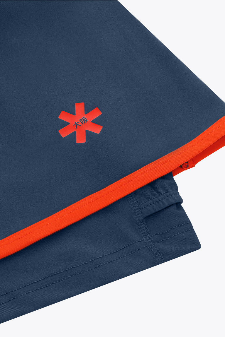 Dark navy skort with red waistband trim, stitched seams, and red starburst logo.