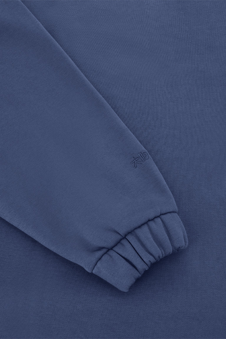 Blue women’s zip polo sweater sleeve cuff with embroidered logo detail