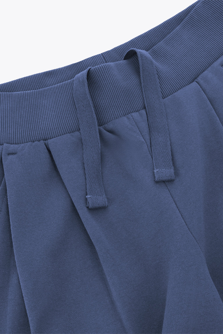 Close-up of dark blue wide-leg sweatpants waistband with elastic ribbing and stitched front