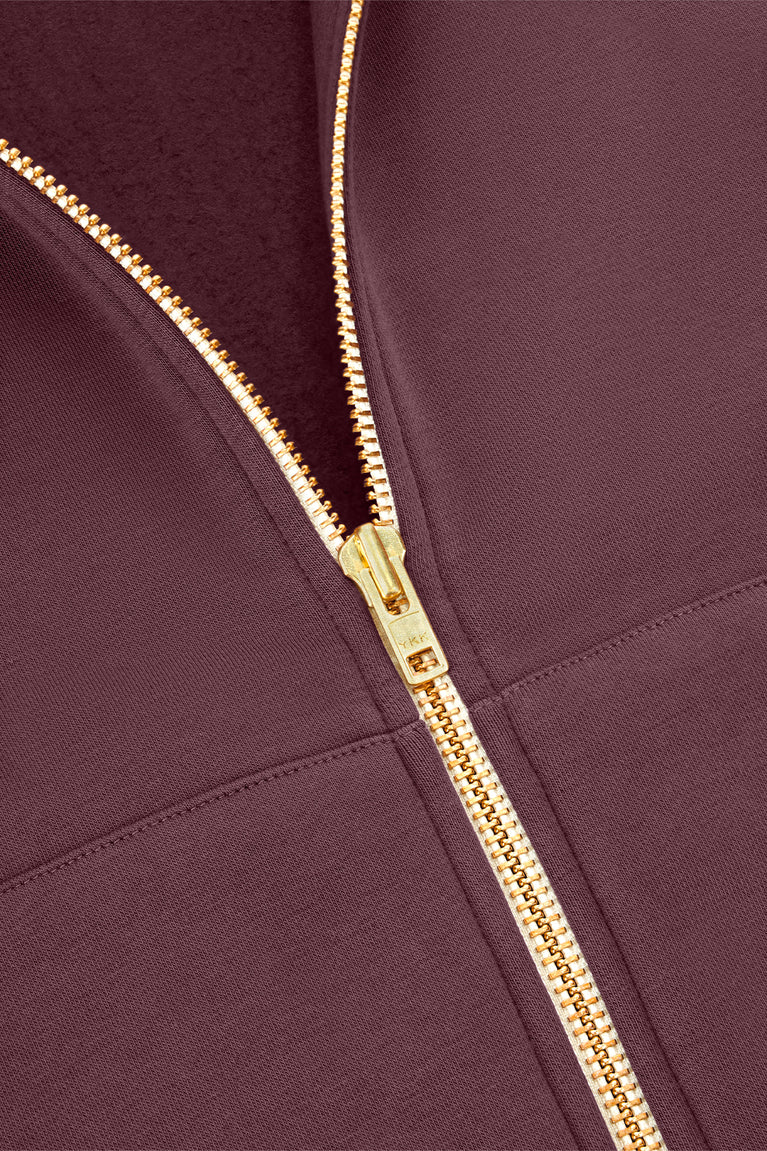 Men's full-zip hoodie zipper close-up, dark maroon jacket with gold chain zipper