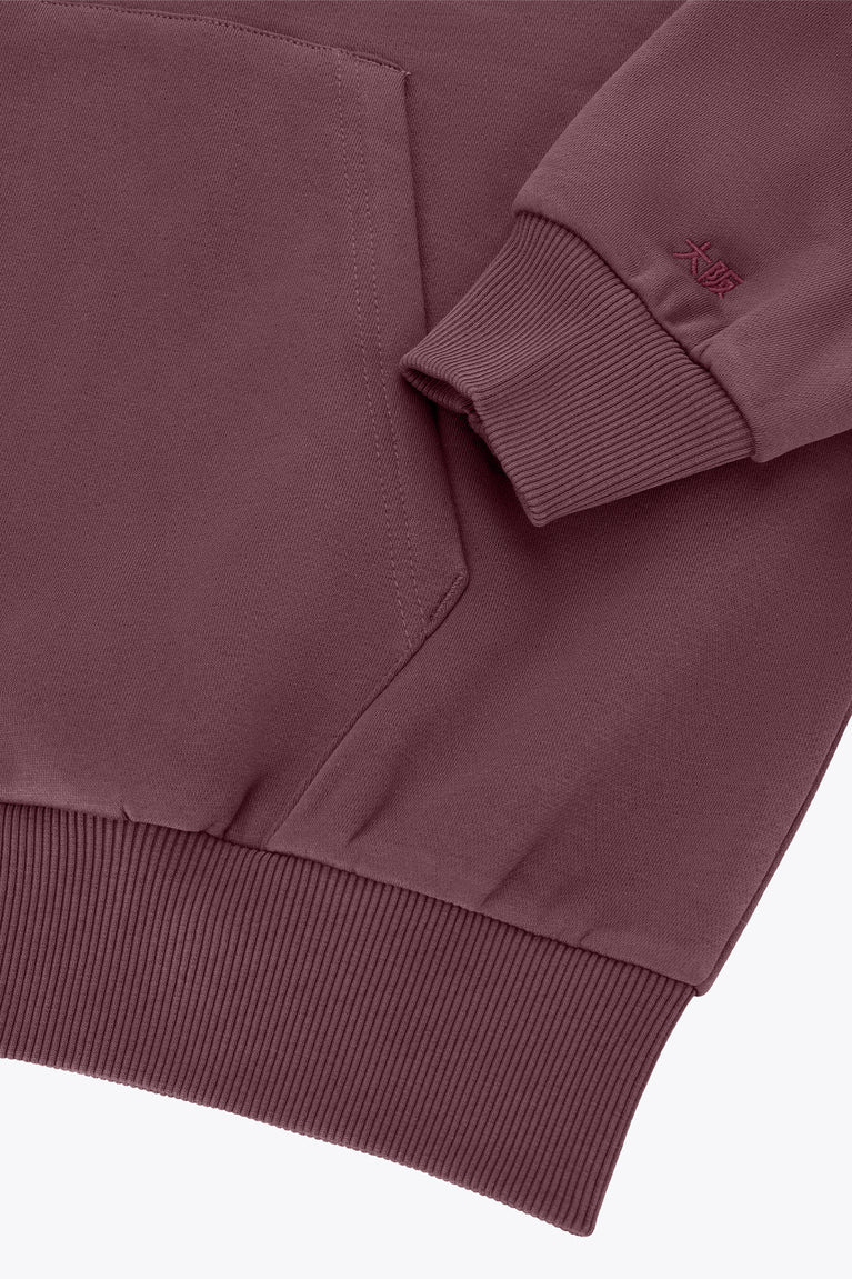 Men's full-zip hoodie detail, dark maroon ribbed cuff and kangaroo pocket with logo