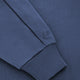Men's navy half-zip sweater sleeve with ribbed cuff and small embroidered logo.