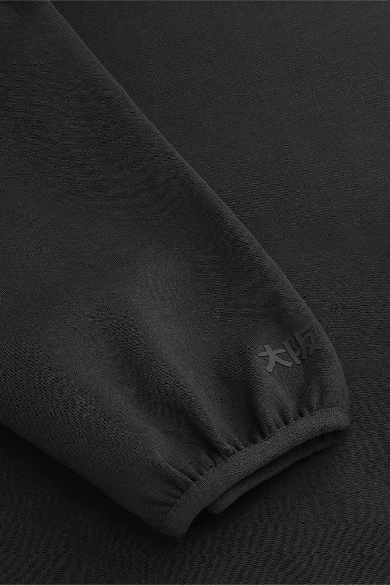 Black sweater sleeve hem with ribbed cuff and stitched seam