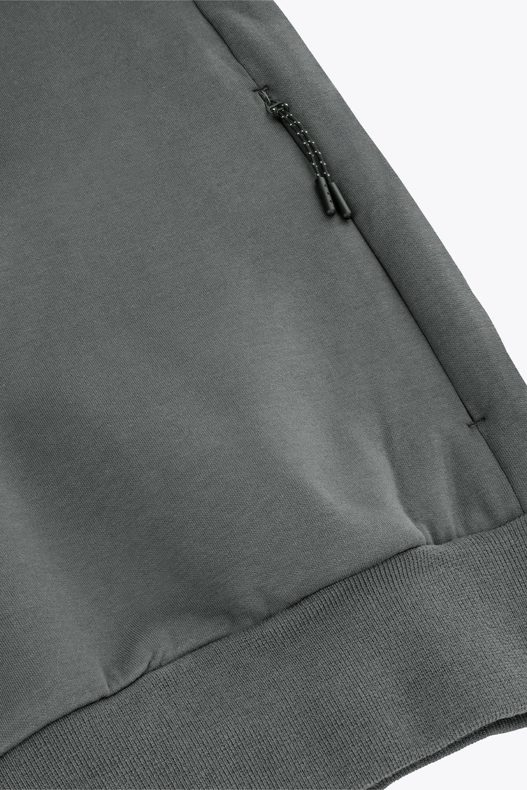 Unisex sweater detail: dark grey melange hem with ribbing and small draw-cord hardware